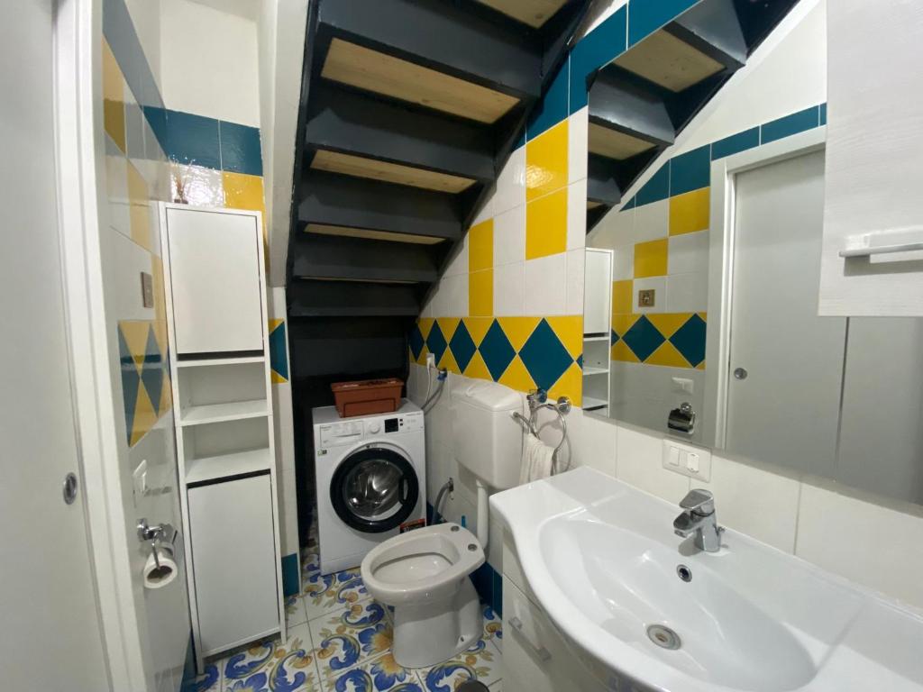 ein Badezimmer mit einem Waschbecken und einer Waschmaschine in der Unterkunft Il Borgo in Sant'Egidio del Monte Albino