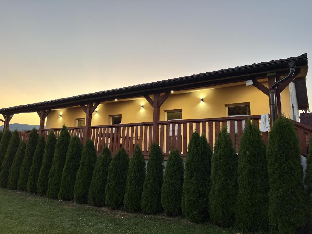 a house with a fence and trees in front of it at Penzion u Tučňaka in Humenné