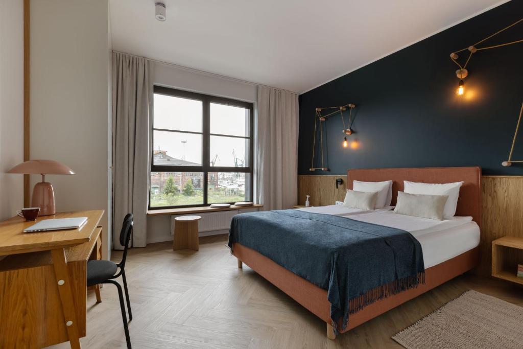 een hotelkamer met een bed, een bureau en een raam bij Solidarność Three Bedroom & Garden Apartment in Gdańsk