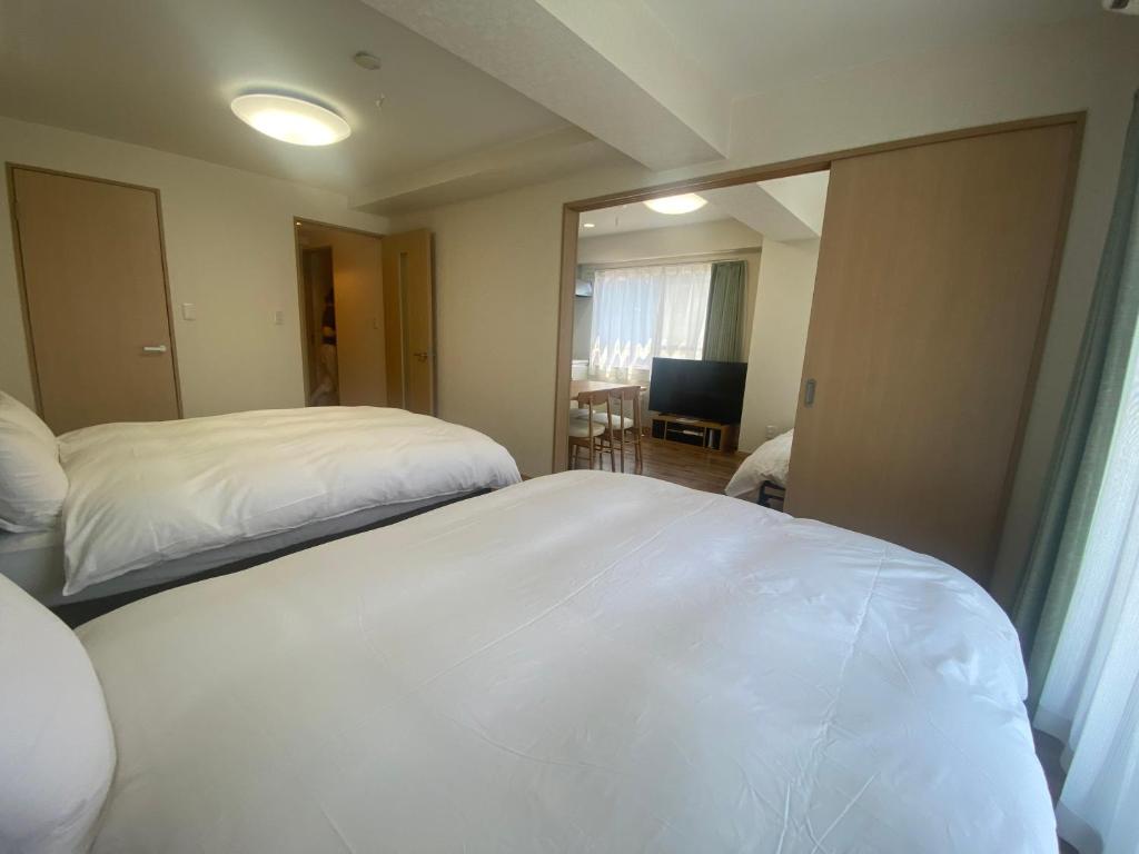 a bedroom with two beds and a mirror at Mezon Akihabara Guest House in Tokyo