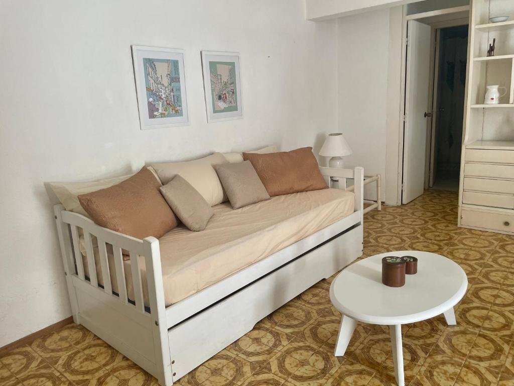 um sofá branco numa sala de estar com uma mesa em Departamento en zona península em Punta del Este