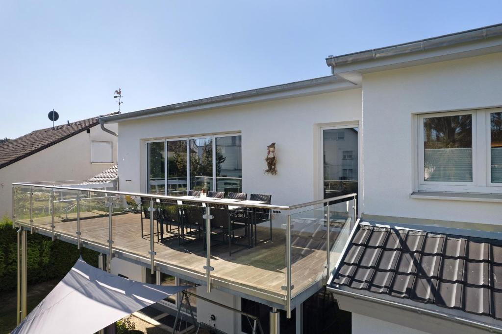 eine Terrasse mit Stühlen und einem Tisch auf einem Haus in der Unterkunft Wolf's Apartment Schwarzwald in Renchen