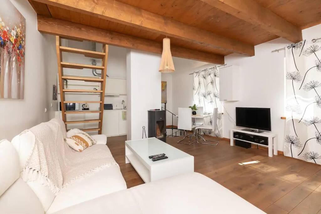 a living room with a white couch and a tv at Cozy 3 story house in Old Town in Tallinn