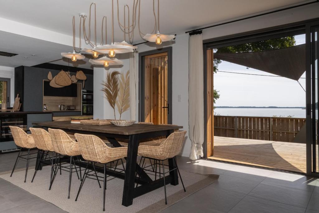 une salle à manger avec une table et des chaises noires dans l'établissement La Maison du Lac, à Lacanau