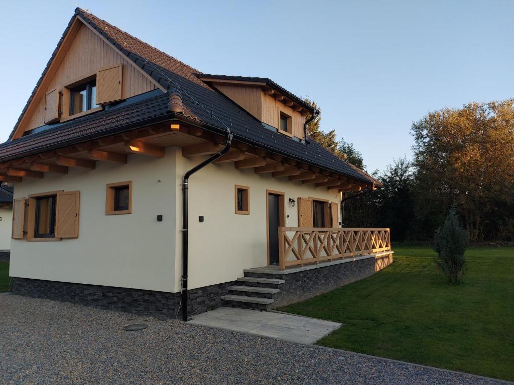 een klein huis met een houten dak en een balkon bij CHALUPY TRI GROŠE VLAŠKY in Bešeňová