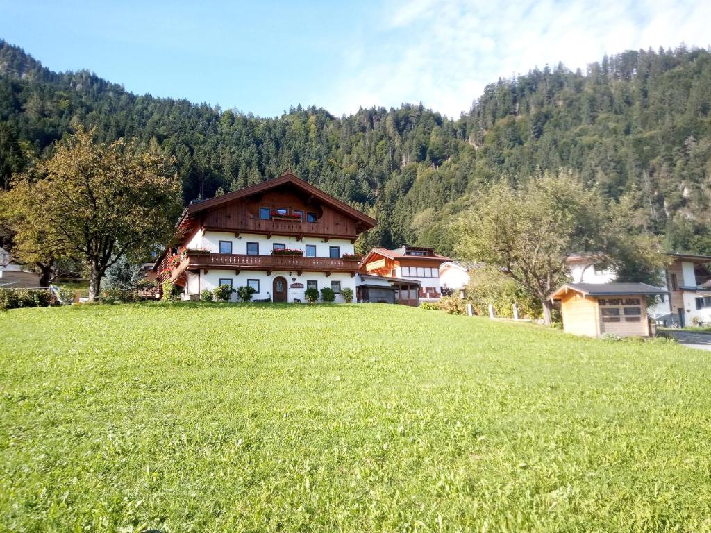 ein großes Haus auf einem Hügel mit grünem Feld in der Unterkunft Jochelerhof in Strass im Zillertal