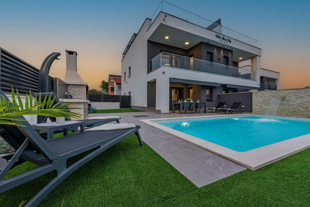 uma villa com piscina em frente a uma casa em Villa Blue Sky 1 em Turanj