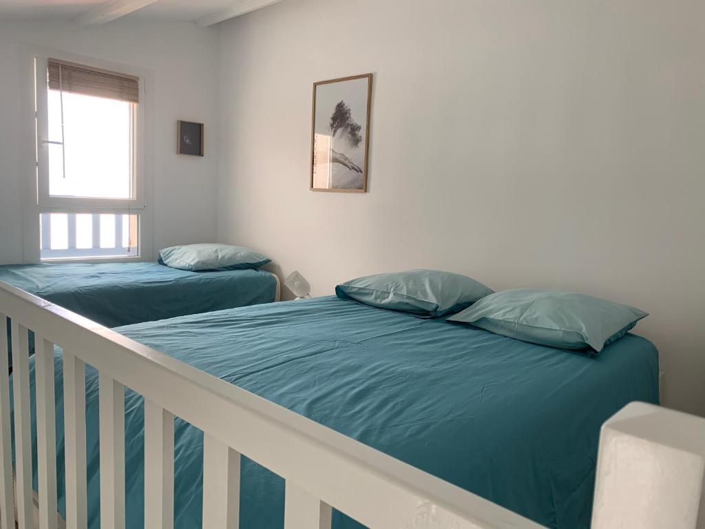 a bedroom with two beds and a crib at Appartement de standing avec terrasse in Saintes-Maries-de-la-Mer
