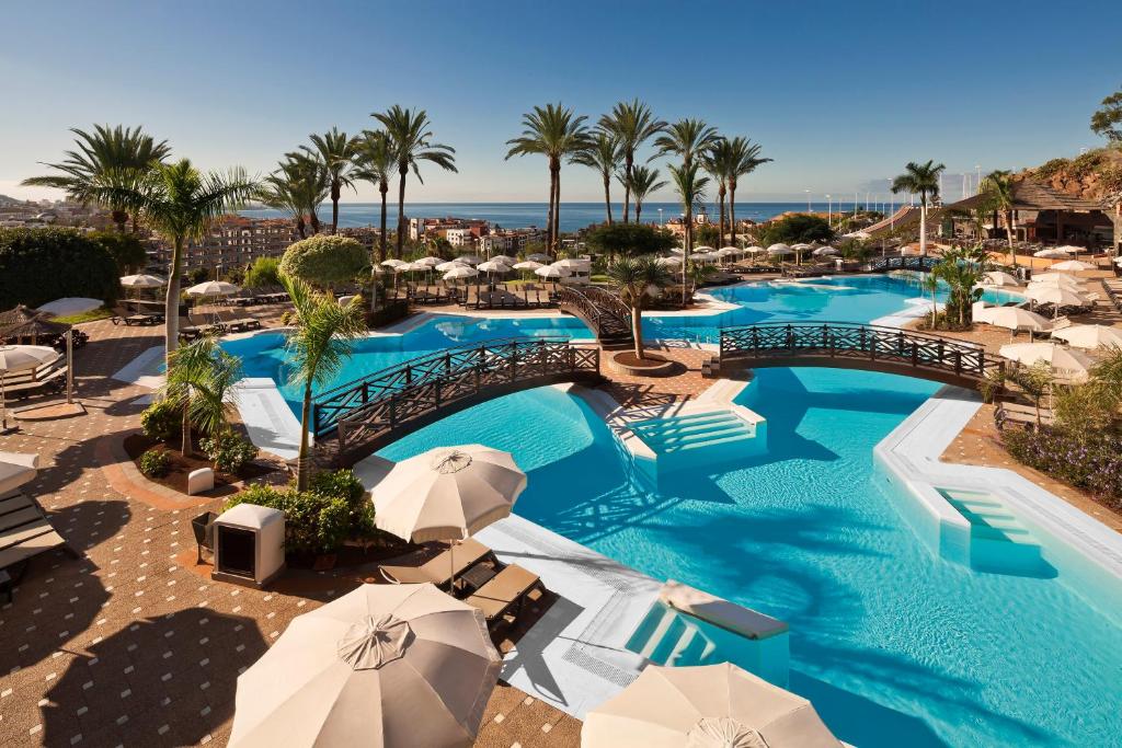 een afbeelding van een zwembad met parasols bij Melia Jardines del Teide - Adults Only in Adeje