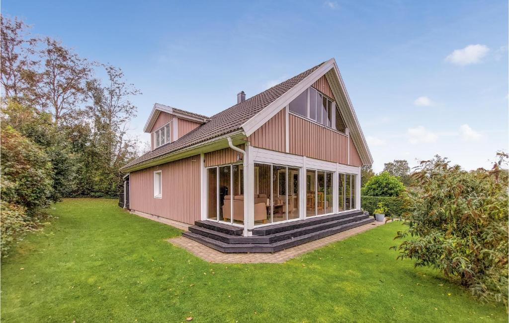 une grande maison rose avec une grande cour dans l'établissement Awesome Home In Bstad With Kitchen, à Båstad