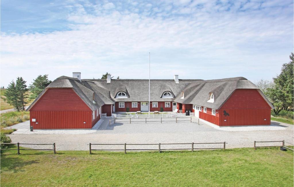 um grande celeiro vermelho com um telhado preto em Stunning Home In Pandrup With Wifi em Rødhus