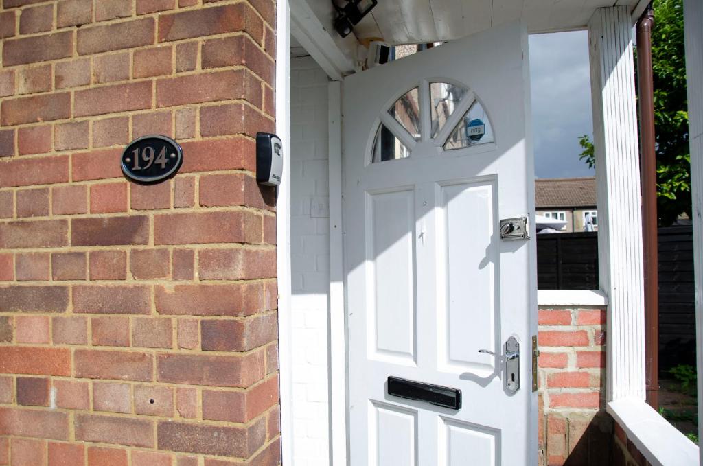 a white door on a brick house with a sign on it at Just Plan B Homes in Forest Hill