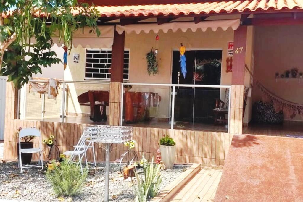 a house with a porch and a patio at Casa em condomínio, churrasqueira privativa e piscina social in Caldas Novas