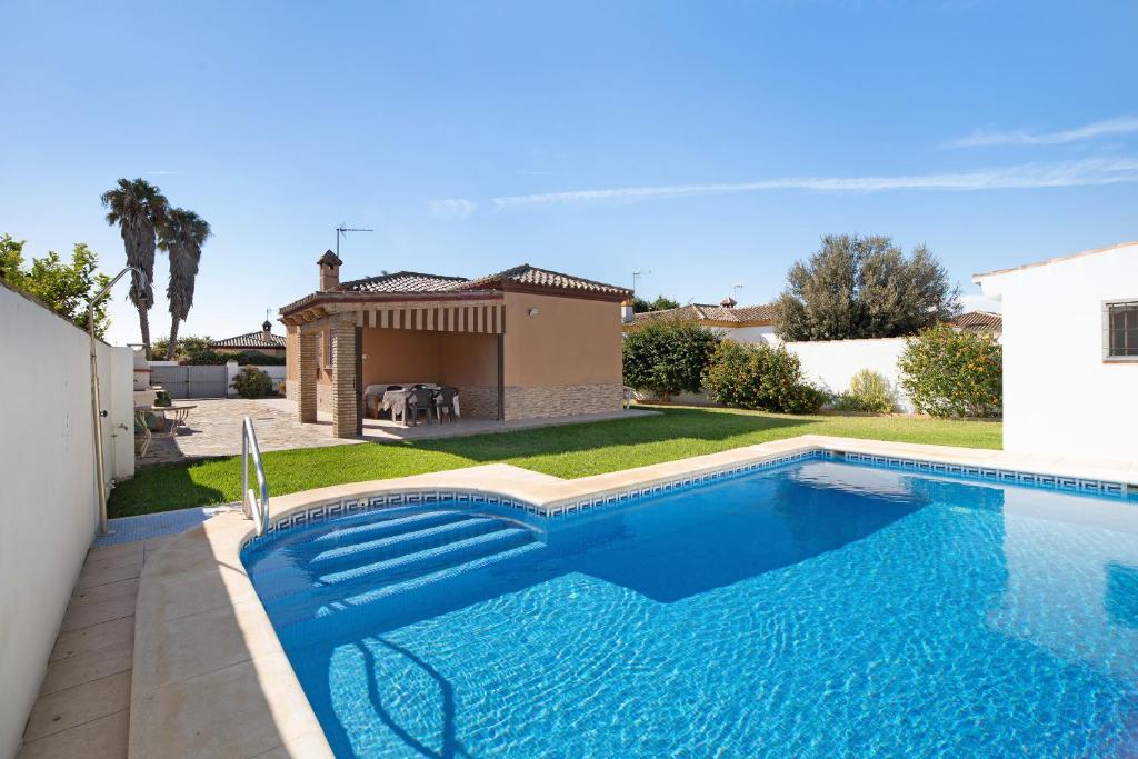 a swimming pool in front of a house at Las Golondrinas in Chiclana de la Frontera