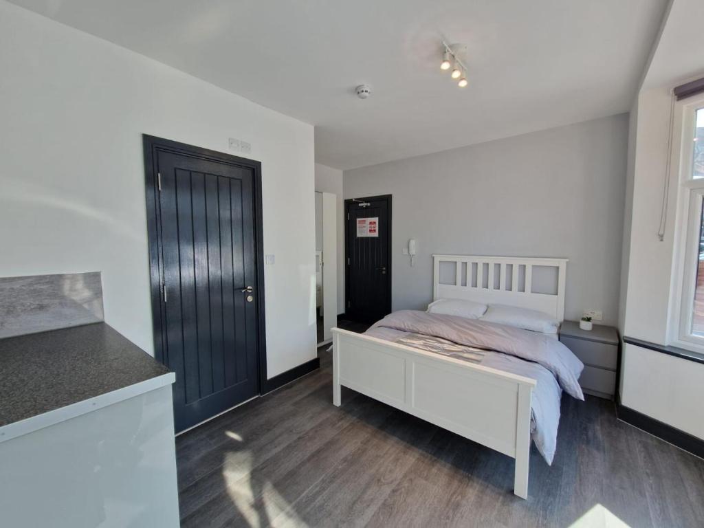 a bedroom with a bed and a black door at Room On Southall High Street in Southall