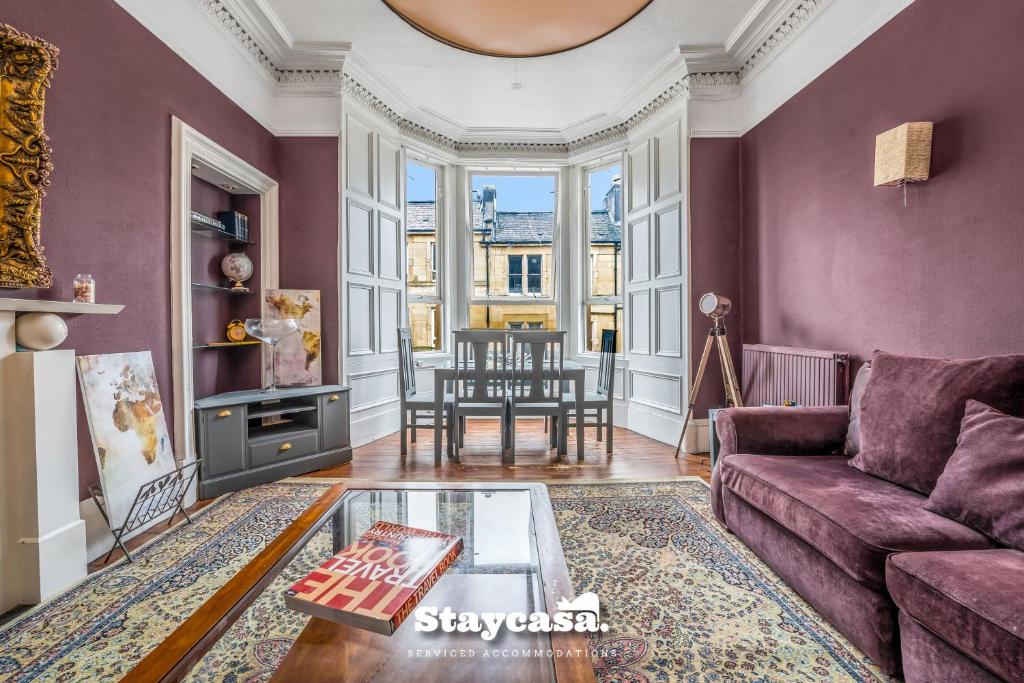 Stunning 3 Bdr Apartment 5 Min From Haymarket في إدنبرة: غرفة معيشة مع جدران أرجوانية وأريكة أرجوانية
