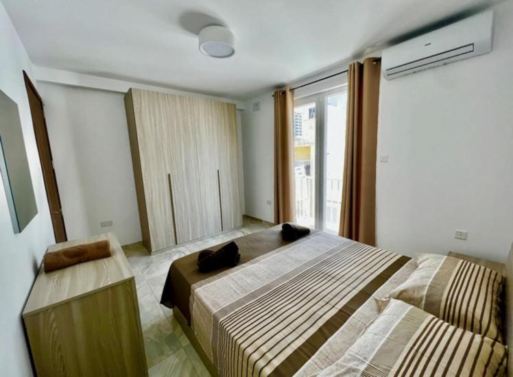 a bedroom with two beds and a window at Saint Henry Sliema in Sliema