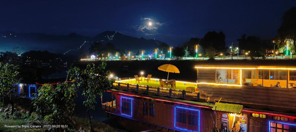 un edificio con una sombrilla y una ciudad por la noche en Houseboat Karima palace, en Srinagar