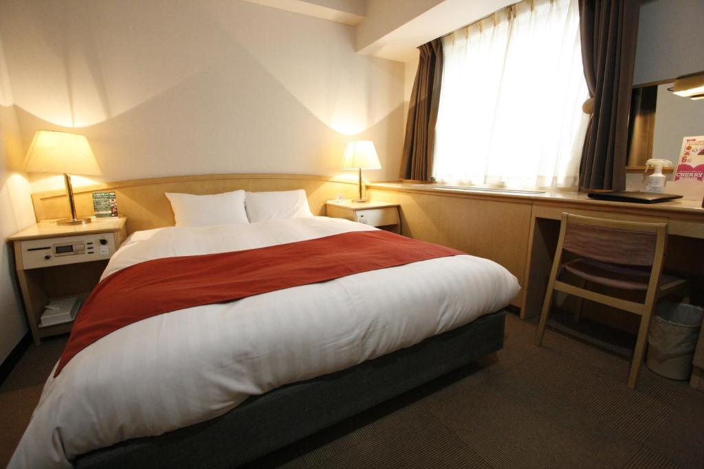 a hotel room with a large bed and a desk at Hotel Abest Meguro in Tokyo