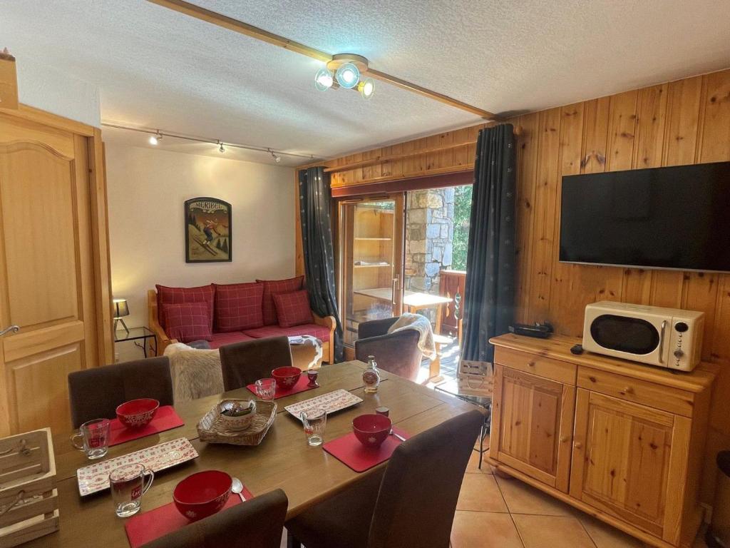 un salon avec une table à manger et une télévision dans l'établissement Charmant T2 cabine pour 4 près du centre et commerces à Méribel, parking inclus - FR-1-411-677, à Les Allues