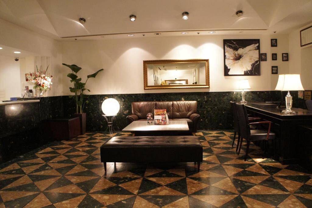 a lobby with a couch and a table and a mirror at Hotel Abest Meguro in Tokyo
