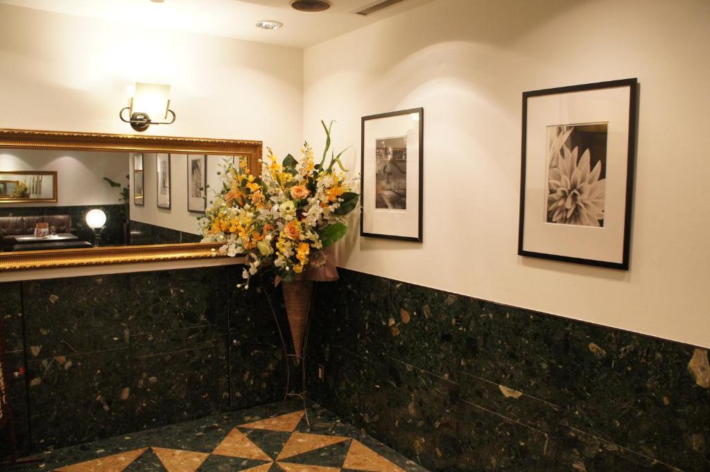 a lobby with a mirror and a bouquet of flowers at Hotel Abest Meguro in Tokyo