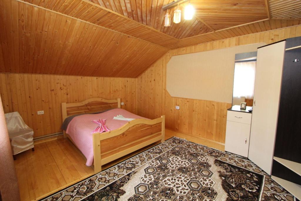 - une chambre avec un lit dans une pièce en bois dans l'établissement Під Піщиком, à Mykulychyn