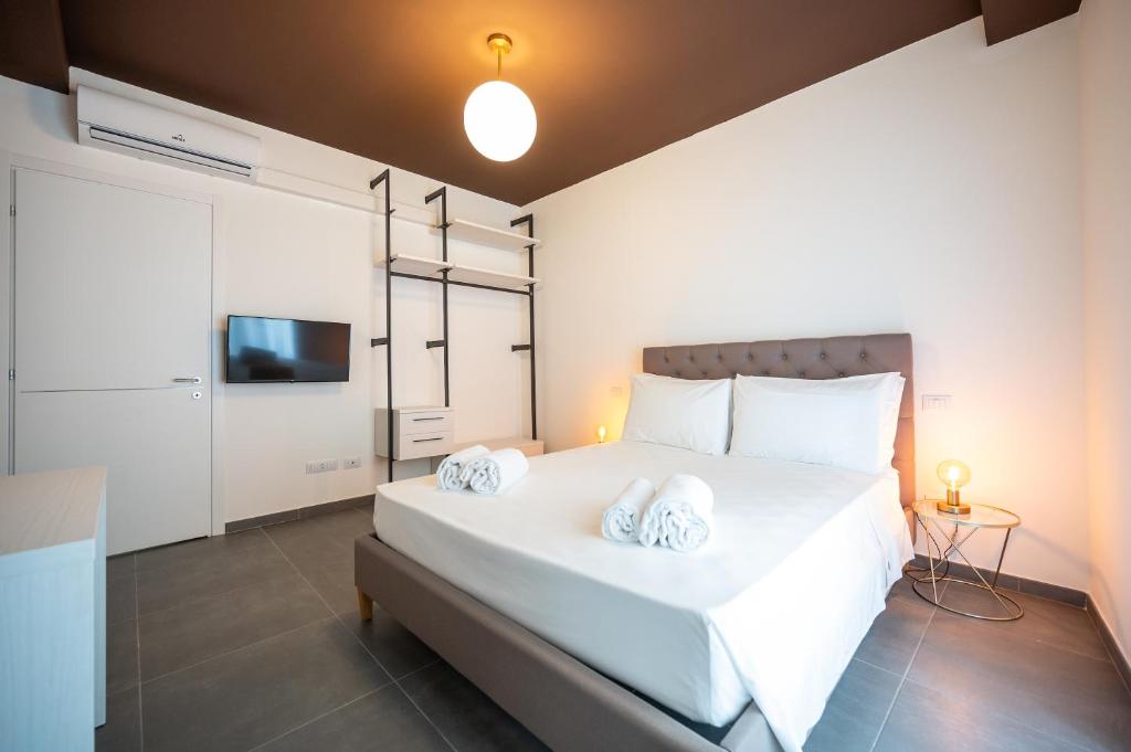 um quarto com uma grande cama branca e 2 almofadas em Porta Nuova Luxury Apartments em Turim