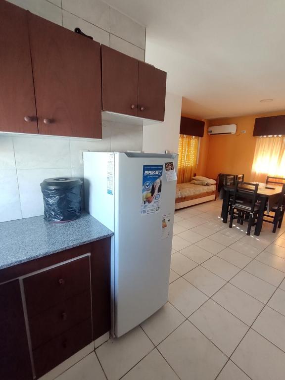 a kitchen with a white refrigerator and a dining room at Los Abuelos 17 in General Pico