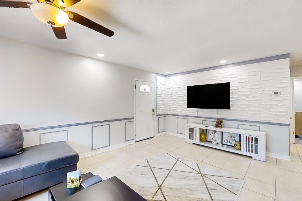 a living room with a couch and a tv on a wall at By the Beach - In-Law Suite in Jacksonville