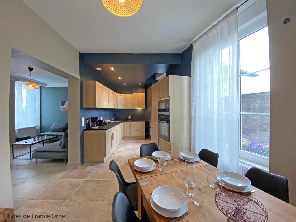 une cuisine et une salle à manger avec une table et des chaises dans l'établissement Gîte de la Poste 6, à Saint-Fraimbault-sur-Pisse