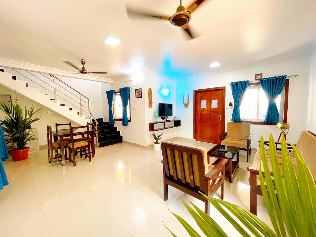 a living room with a dining room table and chairs at Calvin's 3 BDR Villa in Benaulim