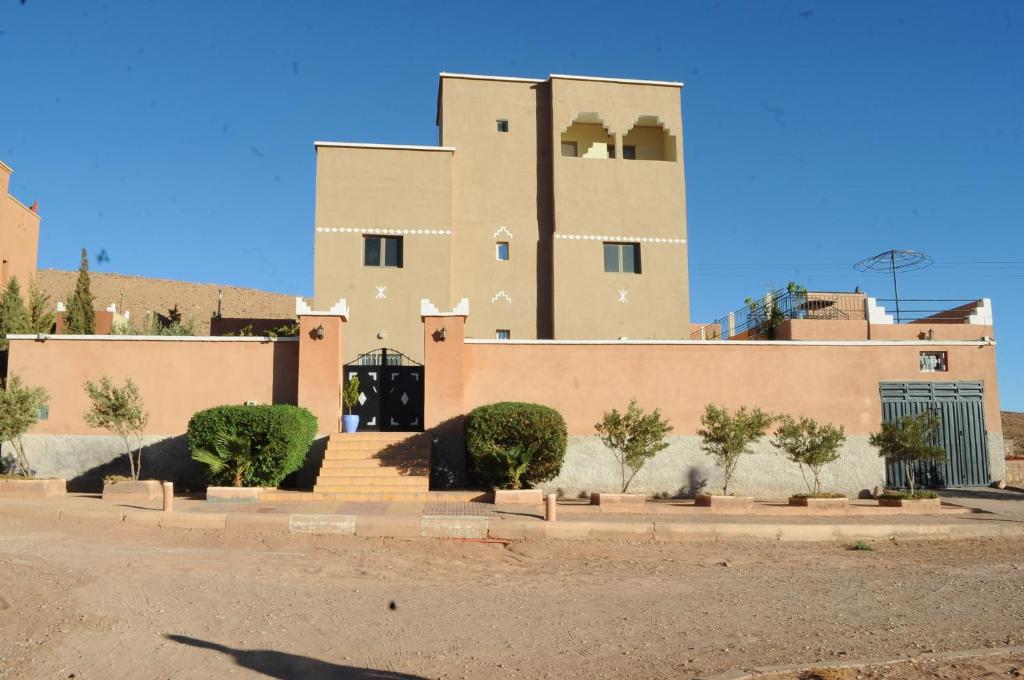 un grand bâtiment avec des arbres devant lui dans l'établissement CHEZ MANAR, à Ouarzazate