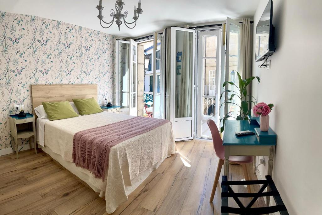 een slaapkamer met een bed, een tafel en een bureau bij Casa da Fonte in Ourense