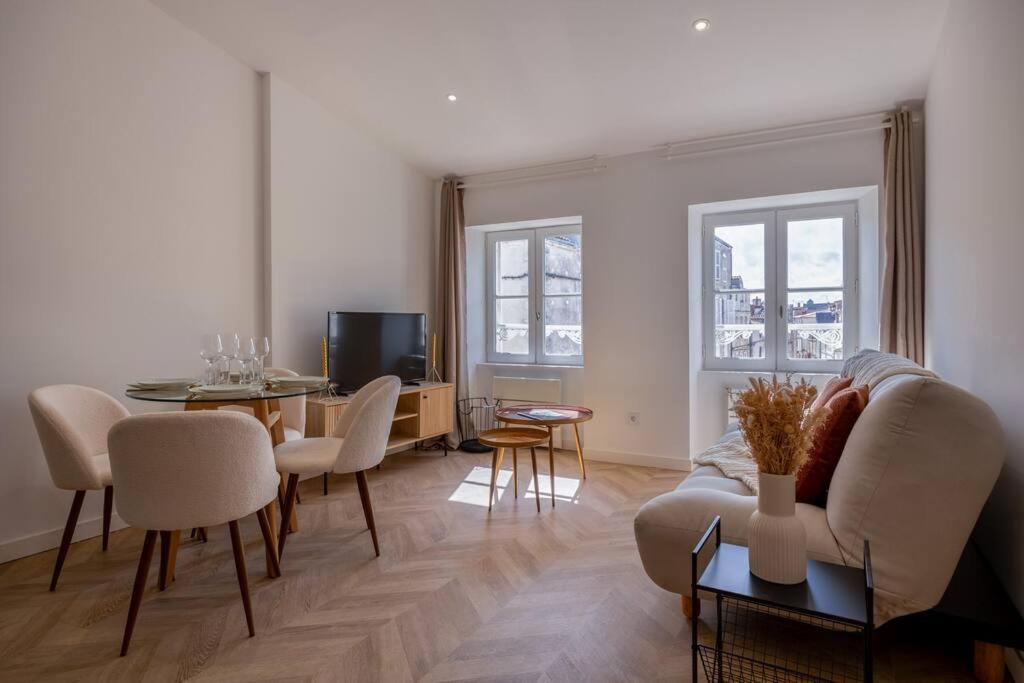 een woonkamer met een bank en een tafel bij La suite d'Orbigny en hyper centre in La Rochelle