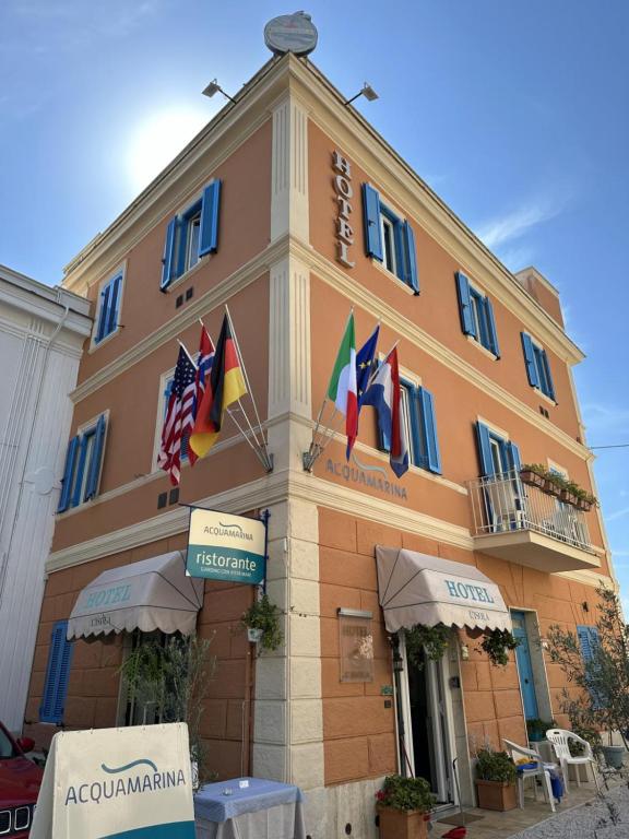 un edificio con banderas en la parte delantera en Hotel L'Isola, en Santa Marinella