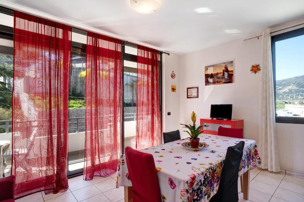 uma sala de jantar com uma mesa e uma janela em Bussana Mare em Bussana Nuova