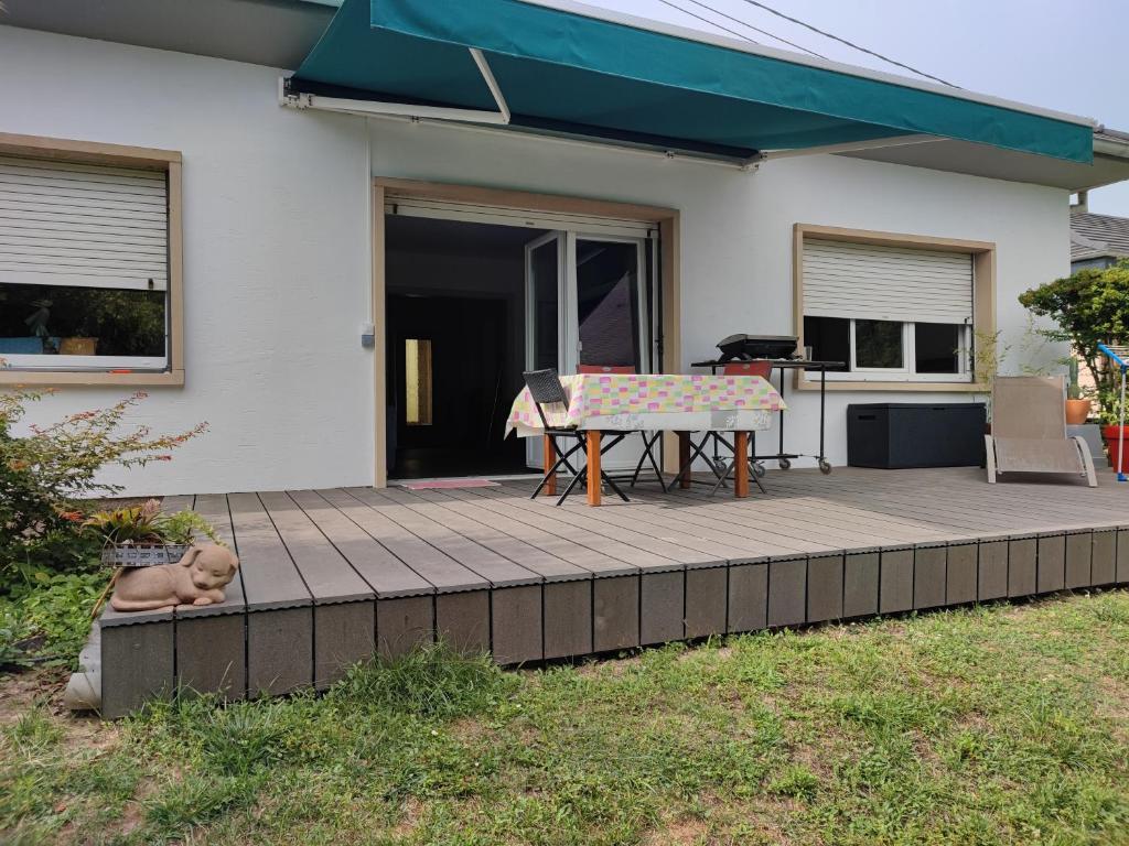 um pátio com uma mesa de piquenique e um cão deitado sobre ele em Villa de plain-pied au calme em Mundolsheim