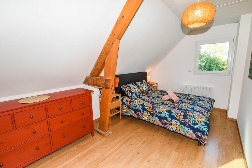 a bedroom with a bed and a dresser and a window at Maison Mélèry in Saint-Pierre-du-Val