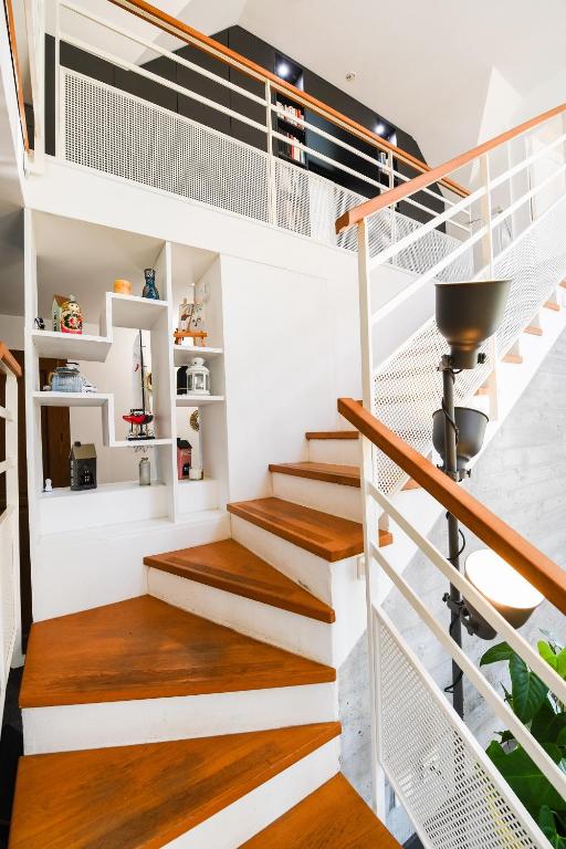 a staircase in a house with white and wood floors at Maison Mélèry in Saint-Pierre-du-Val