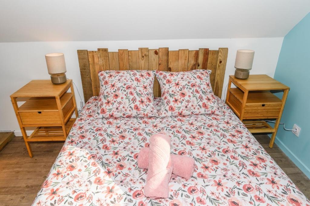 a bed with a pair of pink shoes on it at Maison Mélèry in Saint-Pierre-du-Val