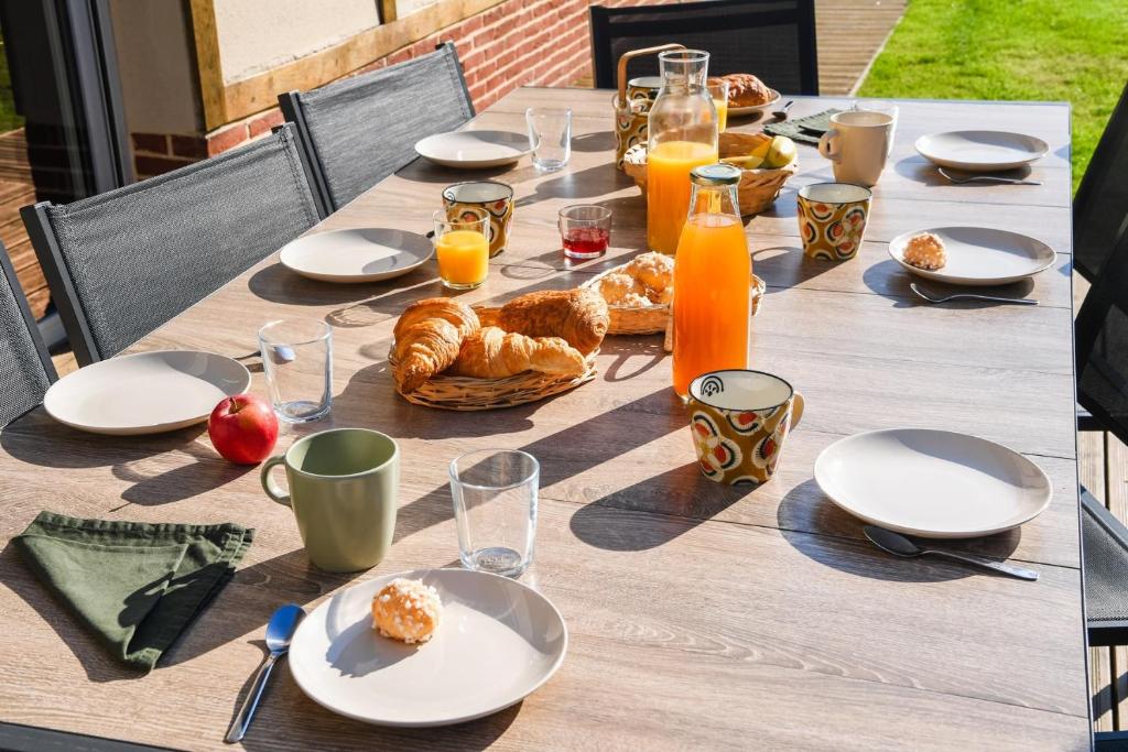 a table with food and orange juice and croissants on it at Maison Mélèry in Saint-Pierre-du-Val