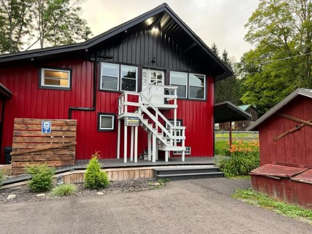 a red house with a staircase on the side of it at Froggy Goggle Barn in Marathon