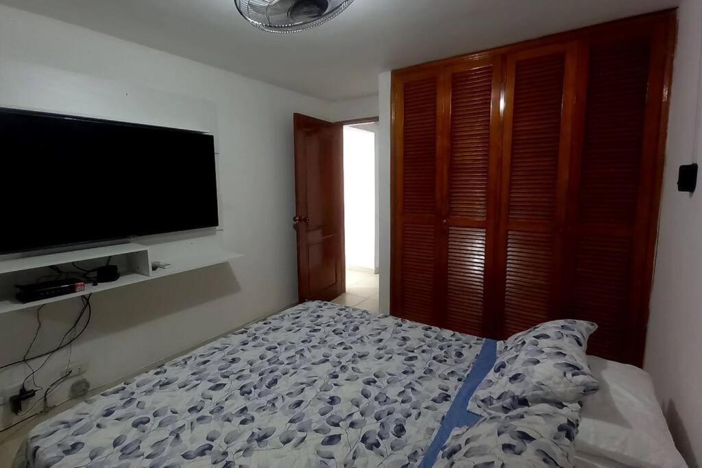 1 dormitorio con 1 cama y TV de pantalla plana en Cómodo Apto piso 3 en Cartagena de Indias