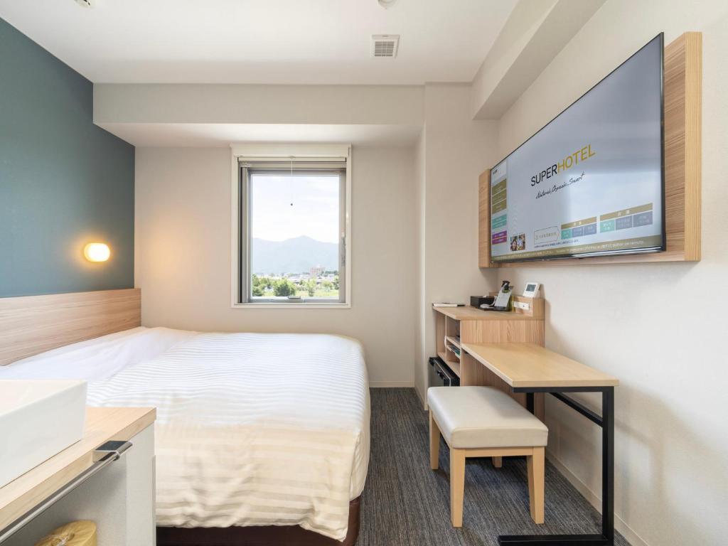 Postel nebo postele na pokoji v ubytování Super Hotel Fujikawaguchiko Tennenonsen