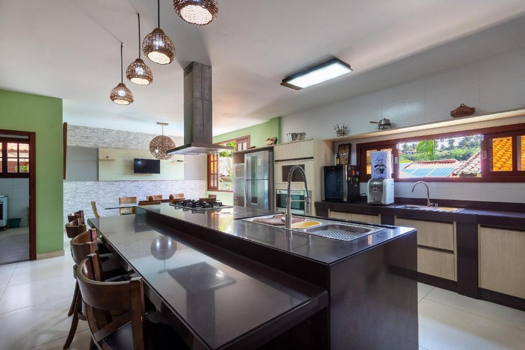 a kitchen with a large island with a counter top at Casa Incrível em Barra do Cunhaú por Carpediem in Canguaretama