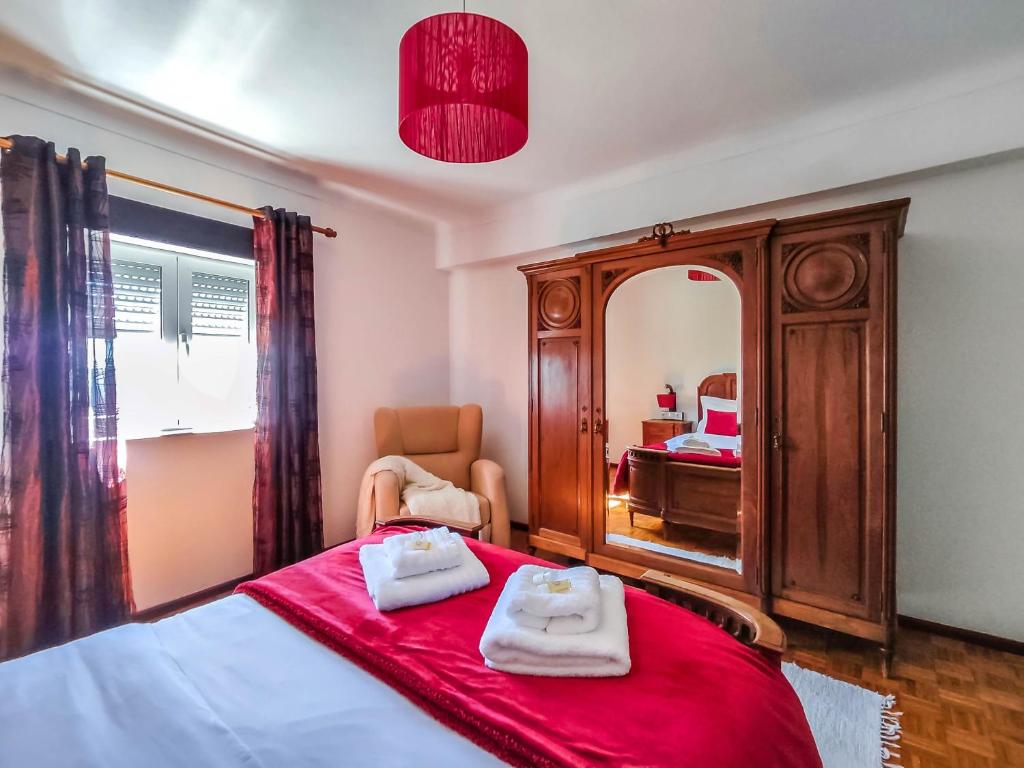 um quarto com uma cama com duas toalhas em Fonte da Rosa Guest House em Belmonte