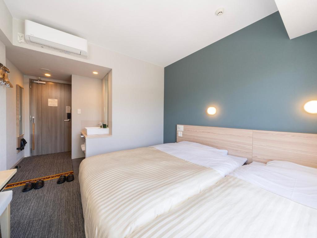 Postel nebo postele na pokoji v ubytování Super Hotel Fujikawaguchiko Tennenonsen