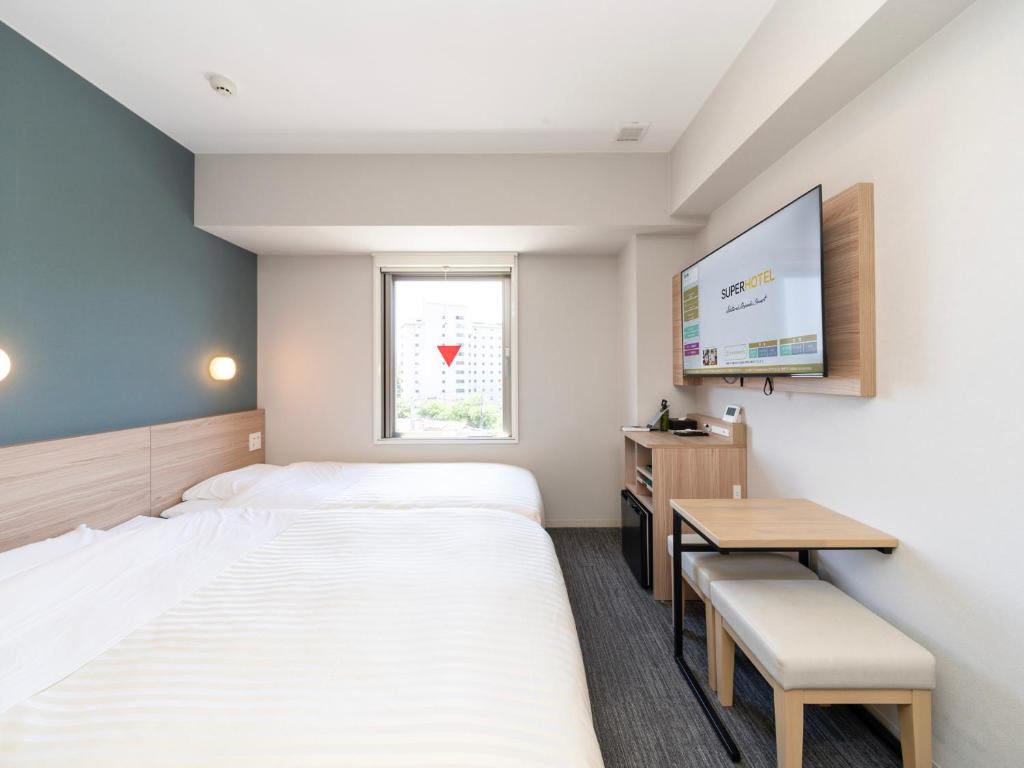 Postel nebo postele na pokoji v ubytování Super Hotel Fujikawaguchiko Tennenonsen