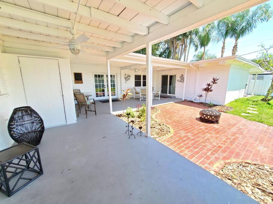 Un patio con piso de ladrillo y una casa blanca. en Large beautiful Magnolia in the sunny Saint Pete., en San Petersburgo